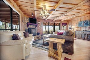 A wooden interior with a fireplace, leather sofas, a wooden coffee table, and a TV. - Black Bear cabin fox Mountain (Franklin)