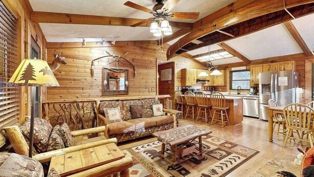 Ein Holzblockhaus-Interieur mit Wohnbereich, Küche und Essbereich.