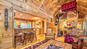 Ein Holzblockhaus-Interieur mit Küche, Essbereich und Wohnzimmer.