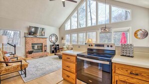 Une cuisine spacieuse dotée d’une grande cuisinière, d’une cheminée en briques et d’un coin repas avec une chaise et une table.