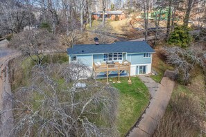 A two-story house with a balcony, a driveway, and a lawn. - The Willows (Waynesville)