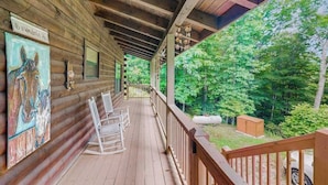 A wooden cabin with a porch, rocking chairs, and a painting. - Walela Cabin (Topton)
