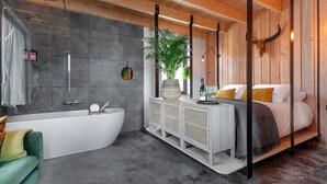Un baño moderno con una bañera independiente, ducha y un espejo grande.