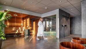 Un vestíbulo moderno con pared de vidrio, mostrador de recepción de madera y zona de piscina.