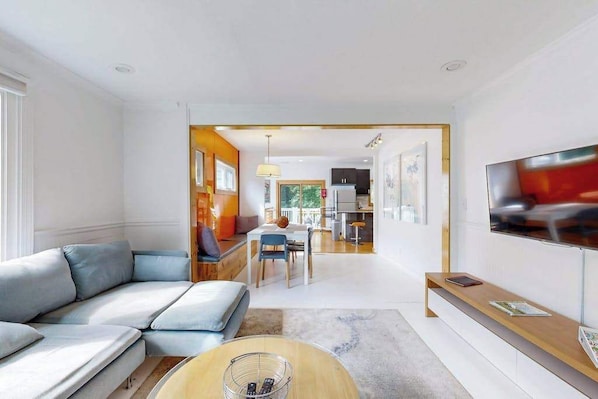 A modern living room with a sofa, a coffee table, and a TV.