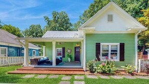 A single-story house with a porch, a covered entryway, and a front yard with stepping stones. - Dog-friendly downtown retreat with 2 kitchens & large fenced yards (Brevard)