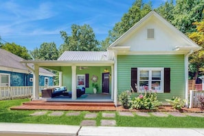 A single-story house with a porch, a covered entryway, and a front yard with stepping stones.