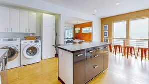 A modern kitchen with built-in appliances, a dining area with a view, and a small island. - Dog-friendly downtown retreat with 2 kitchens & large fenced yards (Brevard)