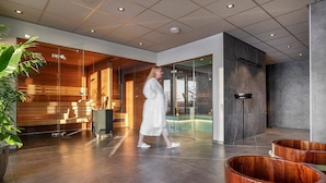 Un vestíbulo moderno con pared de vidrio, mostrador de recepción de madera y zona de piscina.