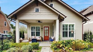 A two-story house with a covered porch, a front door, and a small window. - Downtown Delight | Luxury home, walk to Main Street, bike to trails (Brevard)