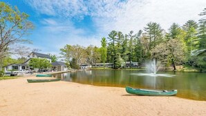 A lakeside property with a sandy beach, boats, and a fountain. - Lakeview pet friendly studio with pool, fire pit, canoes & paddle boats, & WiFi (Flat Rock)