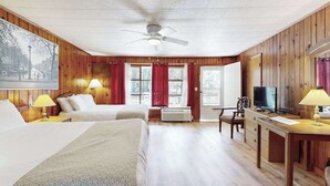 A hotel room with two beds, a desk with a television, and a ceiling fan. - Lakeview pet friendly studio with pool, fire pit, canoes & paddle boats, & WiFi (Flat Rock)