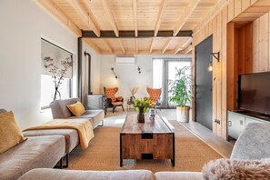 A modern living room with a sofa, coffee table, and TV. - Lennepserf - De Pinkels (Veessen)
