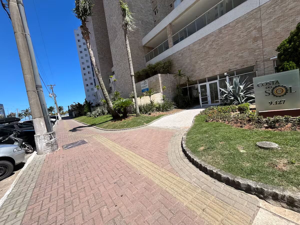 Un vialetto lastricato che conduce a un edificio con un cartello che indica 'Costa do Sol 9.127'.