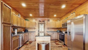 A kitchen with wooden cabinets, stainless steel appliances, and a central island.