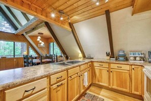 Eine Küche mit Holzschränken, Granit Arbeitsplatten und einem Oberlicht.