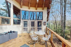 A wooden deck with outdoor seating and a view of the forest. - Two-story, dog-friendly home with two kitchens, central AC, & gas fireplaces (Franklin)