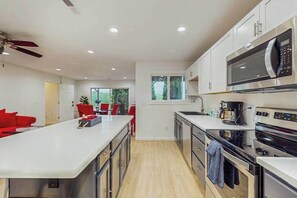 A modern kitchen with a central island, stainless steel appliances, and a view to the outdoors.