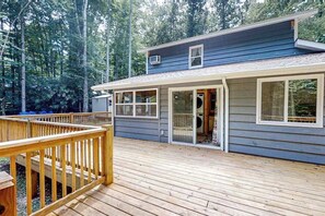 Une maison avec une terrasse, un porche couvert et un garage.