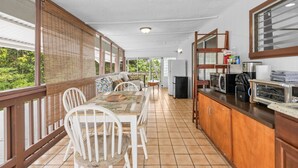 Une cuisine spacieuse avec un coin repas, des meubles en bois et une vue sur la verdure.
