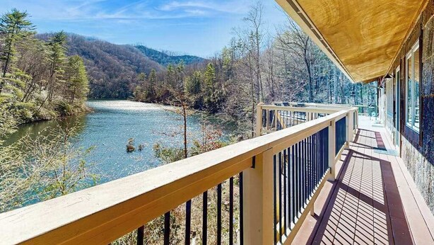 Una terraza de madera con vistas a un río y un bosque.