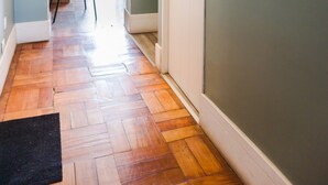 A hallway with wooden flooring, a white door, a mirror, and a view to a balcony. - EmilioVaisse Apartments by Andes STR (Providencia)
