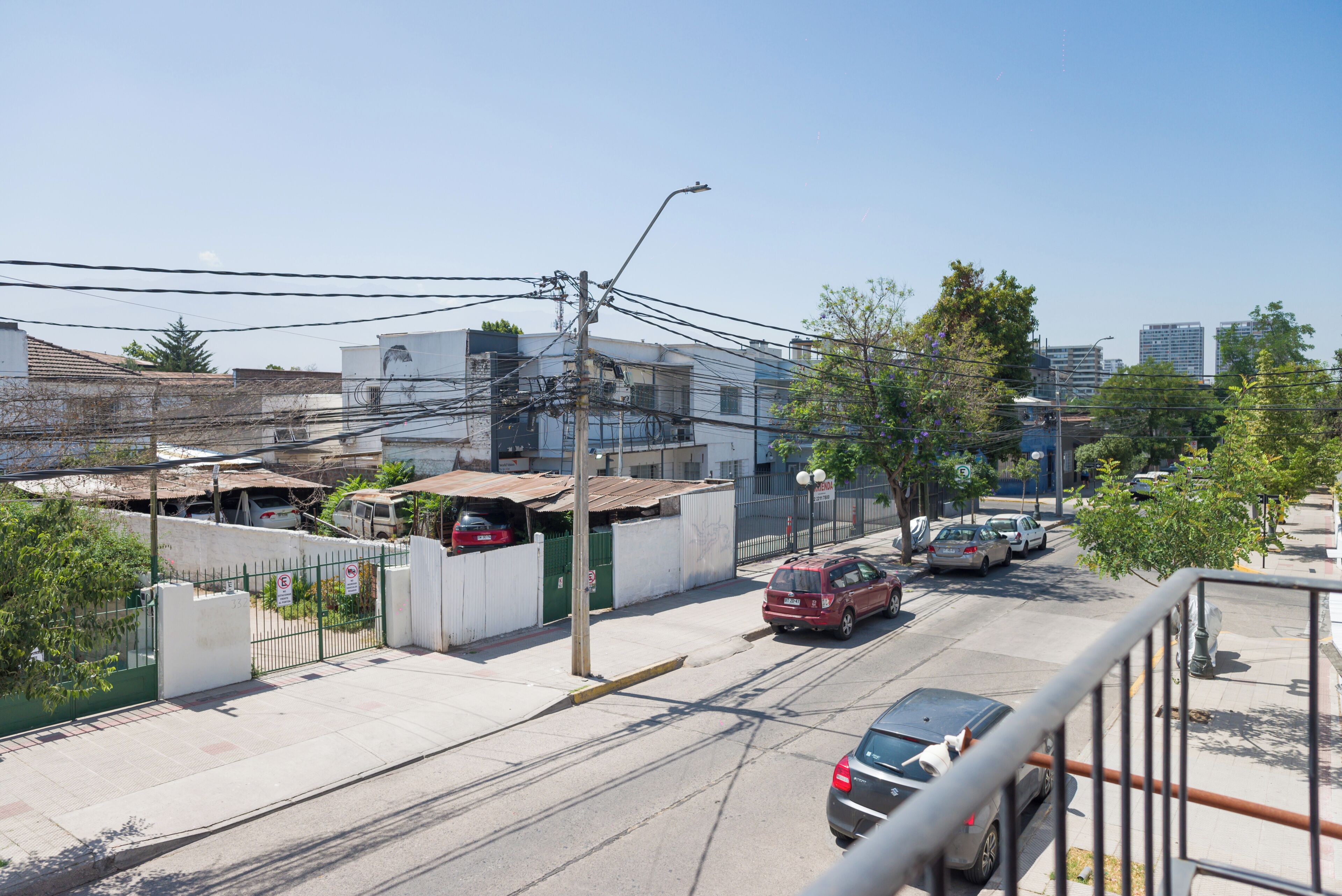 Une vue de rue avec des bâtiments, des voitures et des lignes électriques.