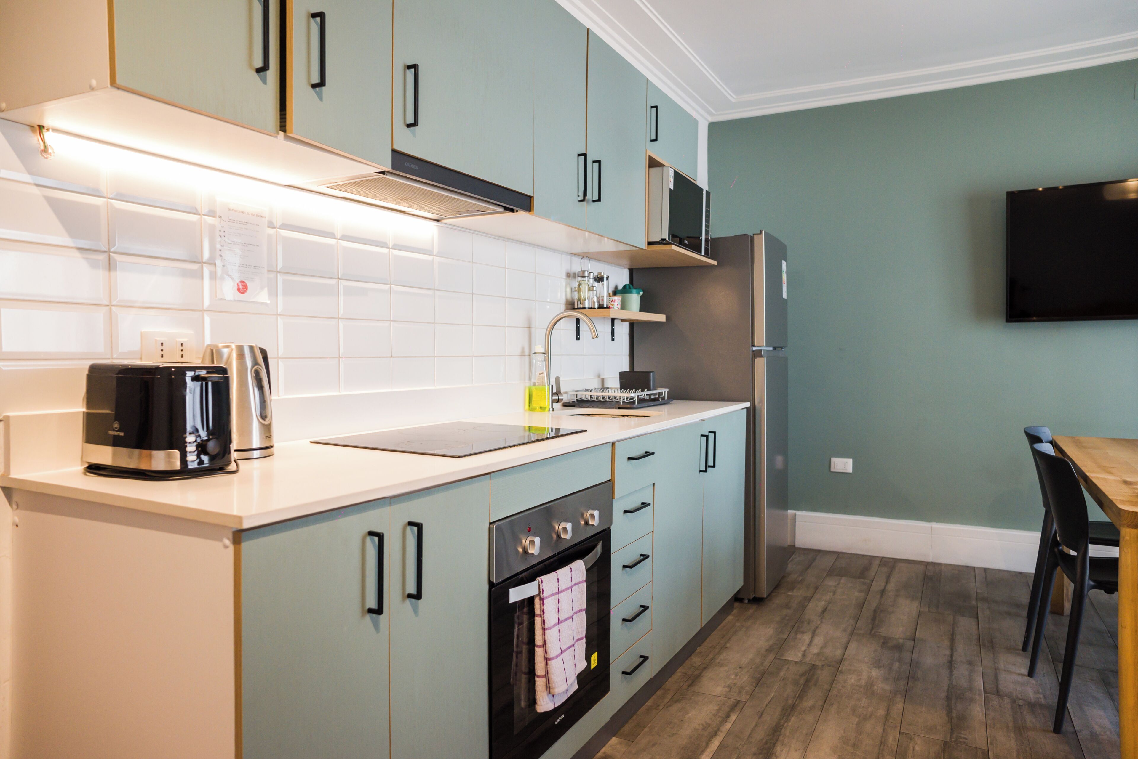 A modern kitchen with a built-in oven, a coffee maker, and a microwave.