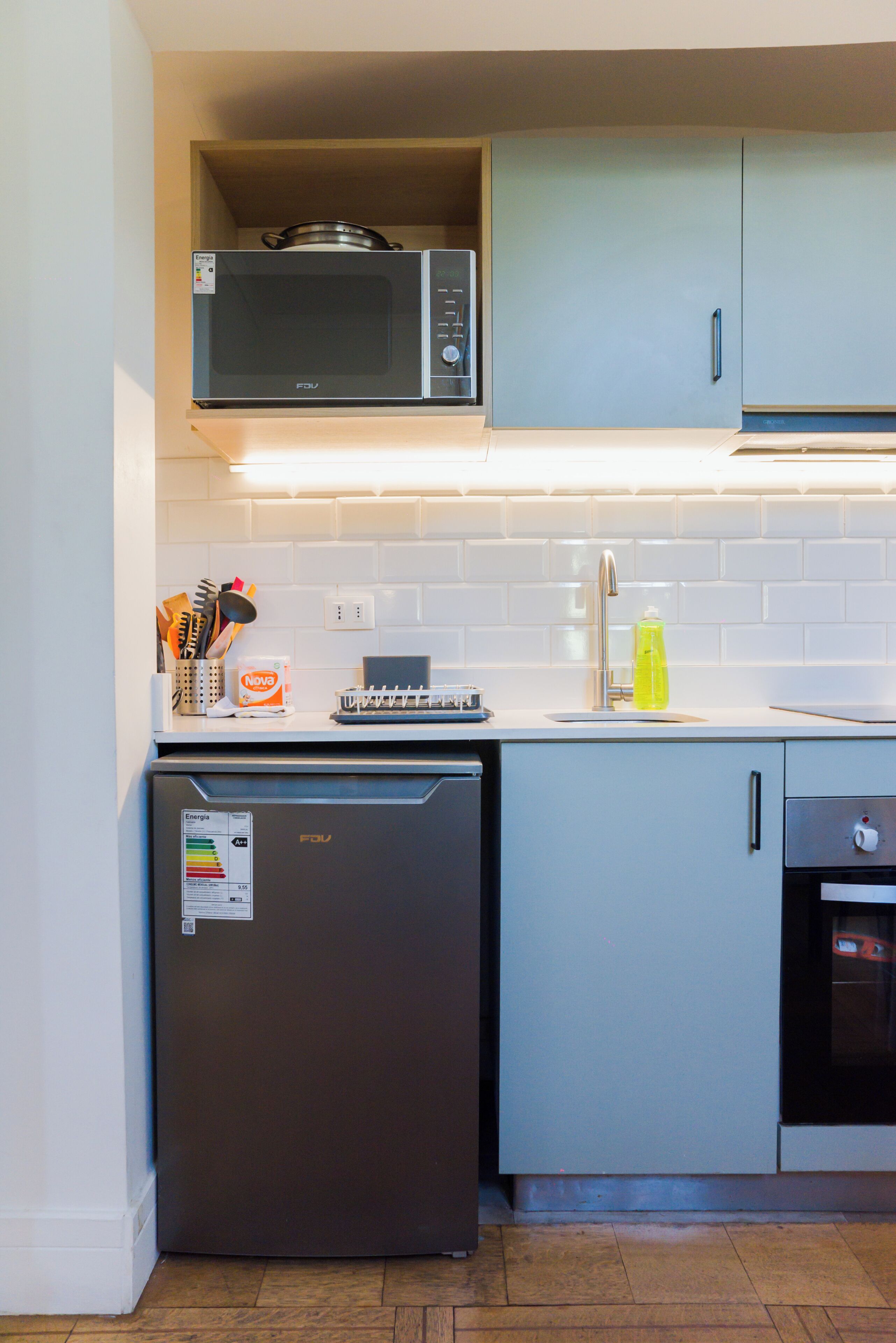 Une cuisine compacte équipée d’un four à micro-ondes, d’un réfrigérateur et d’un évier.