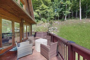 Una terraza techada al aire libre con mobiliario de mimbre y un jacuzzi.