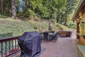 Une terrasse dotée de mobilier d’extérieur, d’un barbecue couvert et d’un jacuzzi.