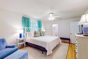 A bedroom with a bed, a nightstand, a chair, a desk, and a ceiling fan. - Blue Ridge Cottage (Waynesville)