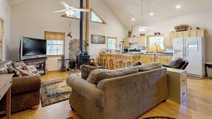 Un salón amplio con un sofá grande, televisor y chimenea.
