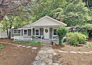Ein eingeschossiges Haus mit Veranda, Eingangstür und kleinem Garten mit trittsteinfreiem Zugang.