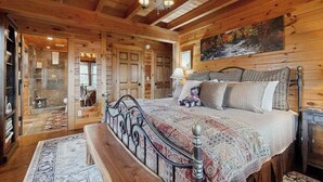 A wooden cabin interior with a bed, bench, and a painting on the wall. - Bear Hug (Sylva)
