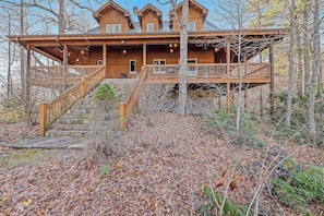 A wooden cabin with a porch, stairs, and a deck. - Timberwolf (Tuckasegee)