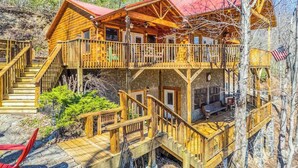 Una baita di legno con un balcone, una scala e una terrazza.