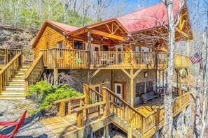 Eine Holzhütte mit Balkon, Treppe und einer Terrasse.