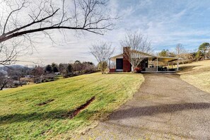 A house with a covered porch, a grassy yard, and a paved driveway. - Sunlit Mountain-View Home w/ Fireplace, WiFi, Alfresco Living & Dining & W/D (Asheville)