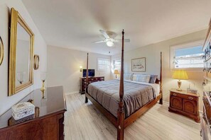 A bedroom with a four-poster bed, a ceiling fan, a television, and a window with a view. - Sunlit Mountain-View Home w/ Fireplace, WiFi, Alfresco Living & Dining & W/D (Asheville)