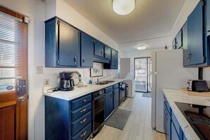 A modern kitchen with dark blue cabinets, a white countertop, and a built-in dishwasher. - Sunlit Mountain-View Home w/ Fireplace, WiFi, Alfresco Living & Dining & W/D (Asheville)