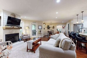 Ein Wohnzimmer mit Kamin, Sofa und Fernseher.