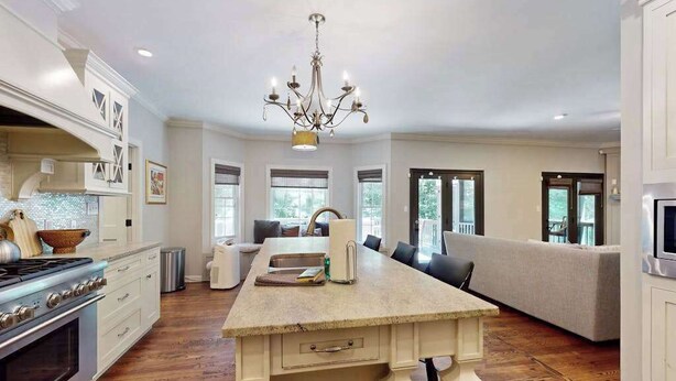 A spacious kitchen with a central island, a built-in oven, and a chandelier. - Expansive Designer Estate w/ TV Room, Spacious Kitchen & Large Yard dog friendly (Arden)