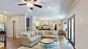 A modern living room with a sectional sofa, a round coffee table, and a ceiling fan. - Expansive Designer Estate w/ TV Room, Spacious Kitchen & Large Yard dog friendly (Arden)