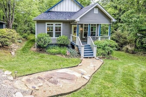 Ein Haus mit einer Veranda, einem Kiesweg und einem kleinen Garten.