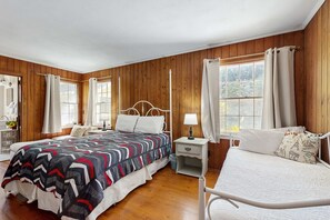 A bedroom with a bed, bedside tables, a lamp, and curtains.