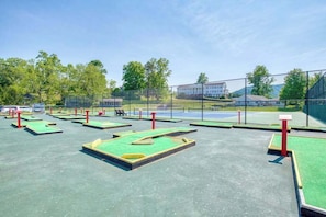 Et udendørs golf driving range med flere tee-spots og et netindhegnet område.