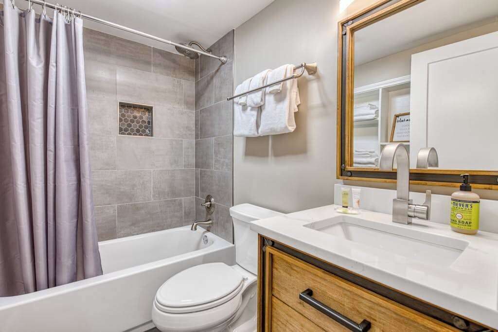 A bathroom with a bathtub, toilet, and sink.