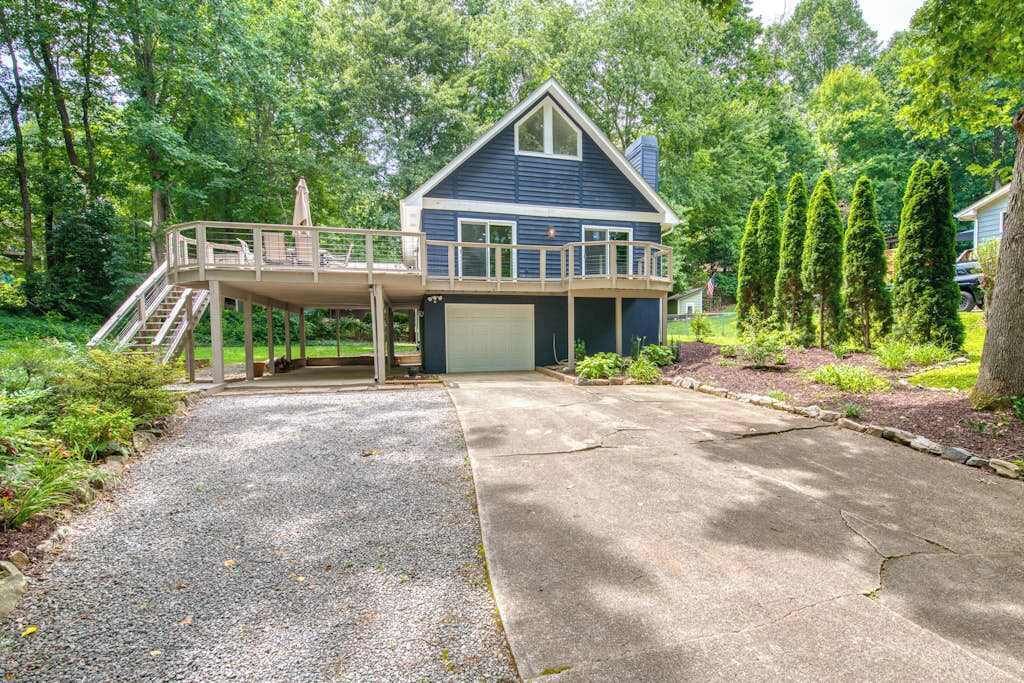 Een huis met twee verdiepingen, een overdekt terras en een garage.
