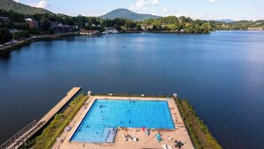 Ein Schwimmbecken mit Blick auf einen See und Berge im Hintergrund.